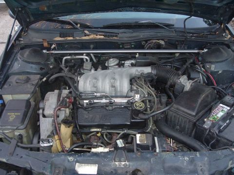 1993 Ford Taurus - The engine bay of a 1993 Ford Taurus is visible, with the V6 engine and associated components clearly displayed.