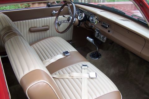 1965 Ford Falcon - The interior of a 1965 Ford Falcon shows its beige and brown seats, dashboard, and steering wheel.