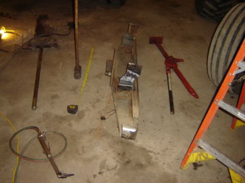 1992 Ford Bronco - Tools and metal parts are laid out on a workshop floor, suggesting a repair or fabrication project.
