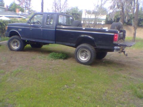 1987 Ford F-250 - This 1987 Ford F-250 crew cab pickup truck is shown from the side in a grassy yard.