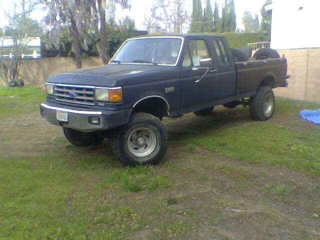 1987 Ford F-250 pickup truck, dark blue, parked on grass