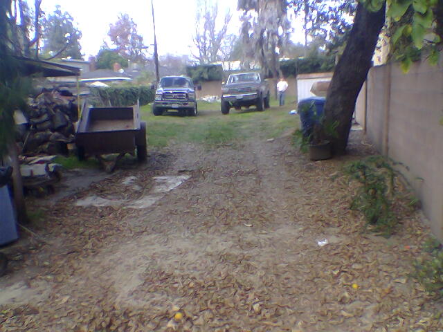 1987 Ford F-250 parked in a yard with another pickup truck