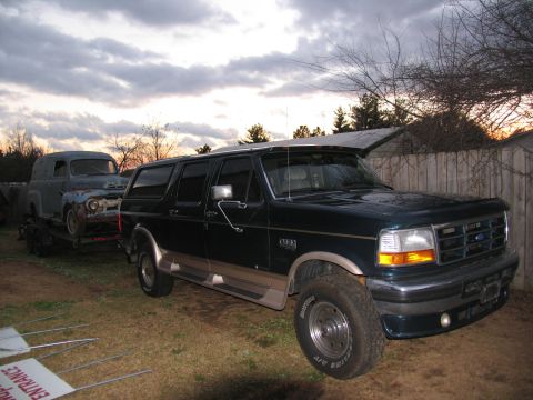 1952 Ford Panel Van - 1952 Ford panel van on trailer, towed by dark green Ford Bronco.
