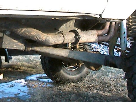 1977 Ford F-150 - A close-up view of the undercarriage of a truck, showing the exhaust pipes and suspension system.