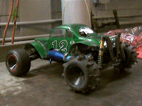 1977 Ford F-150 - A green radio-controlled car with oversized tires sits on a concrete floor.