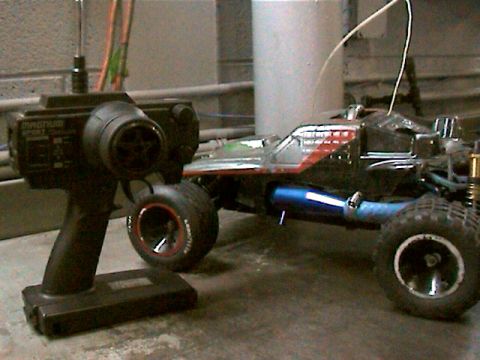 1977 Ford F-150 - A remote control car and its controller are shown, with the car a blue exhaust pipe and red and silver racing stripes.