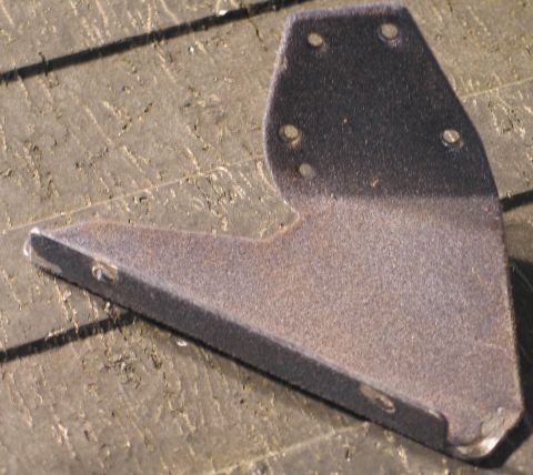 1994 Ford Bronco - A metal bracket with mounting holes is shown against a textured wooden background.