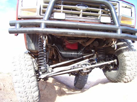1984 Ford Bronco - Front view of a red 1980 Ford Bronco, its suspension and grille with an aftermarket bumper.