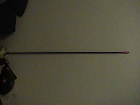 1994 Ford Bronco - A long CB antenna is shown mounted against a wall, with a red tip visible.