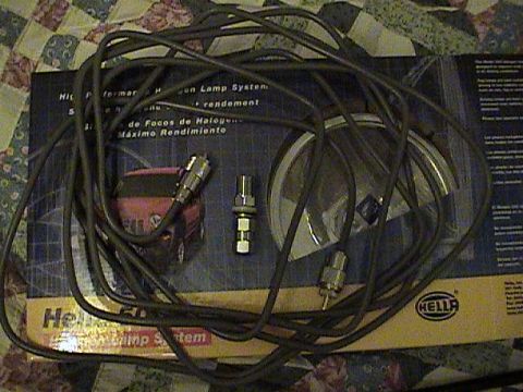 1994 Ford Bronco - A Hella Halogen Lamp System kit is laid out on a patterned surface.