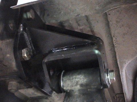 1994 Ford Bronco - Close-up of a suspension bracket installation on a vehicle's undercarriage.