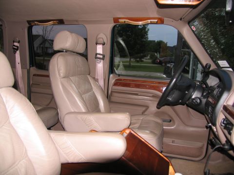 1995 Ford C-150 (Centurion Conversions) - The interior of this 1995 Ford C-150 Centurion Conversion van features comfortable captain's chairs and elegant wood accents.