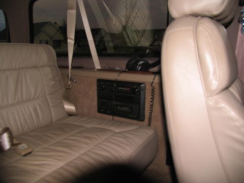 1995 Ford C-150 (Centurion Conversions) - The interior of a van features tan leather seats and a stereo system mounted on the wall.