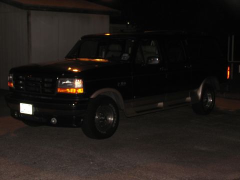1995 Ford C-150 (Centurion Conversions) - Black 1995 Ford C-150 (Centurion Conversions) SUV parked outdoors at night.