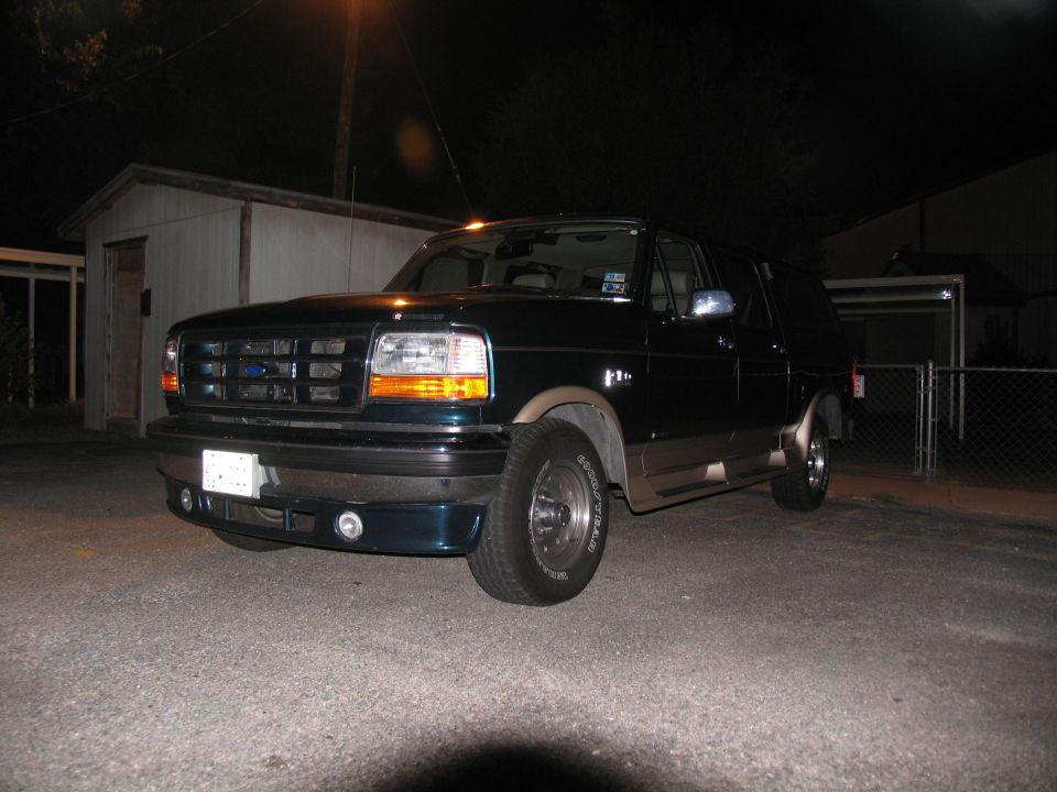 Dark green Ford Bronco with tan trim, parked at night