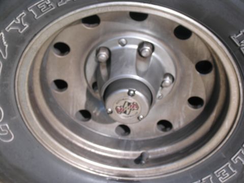 1995 Ford C-150 (Centurion Conversions) - A close-up view of a vehicle's wheel hub and tire, showing the "4x4" emblem.