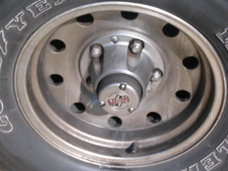 Close-up of a silver wheel hub with a "4x4" emblem and tire tread