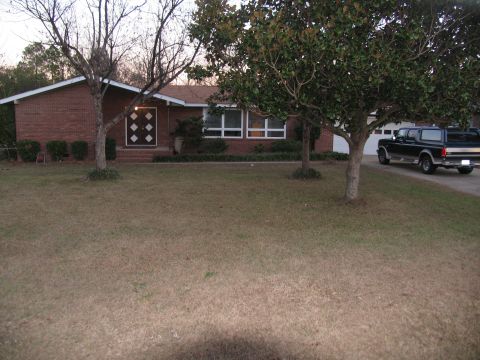 1995 Ford C-150 (Centurion Conversions) - A black pickup truck is parked on a driveway in front of a brick house.