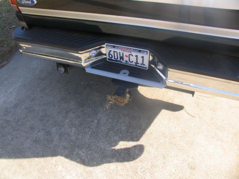 1995 Ford C-150 (Centurion Conversions) - The rear of a Ford truck, showing the bumper, hitch, and a Texas license plate.