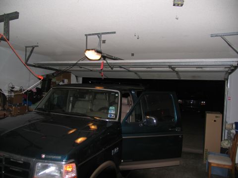 1995 Ford C-150 (Centurion Conversions) - Dark green 1995 Ford C-150 (Centurion Conversions) with driver's door ajar in a garage.