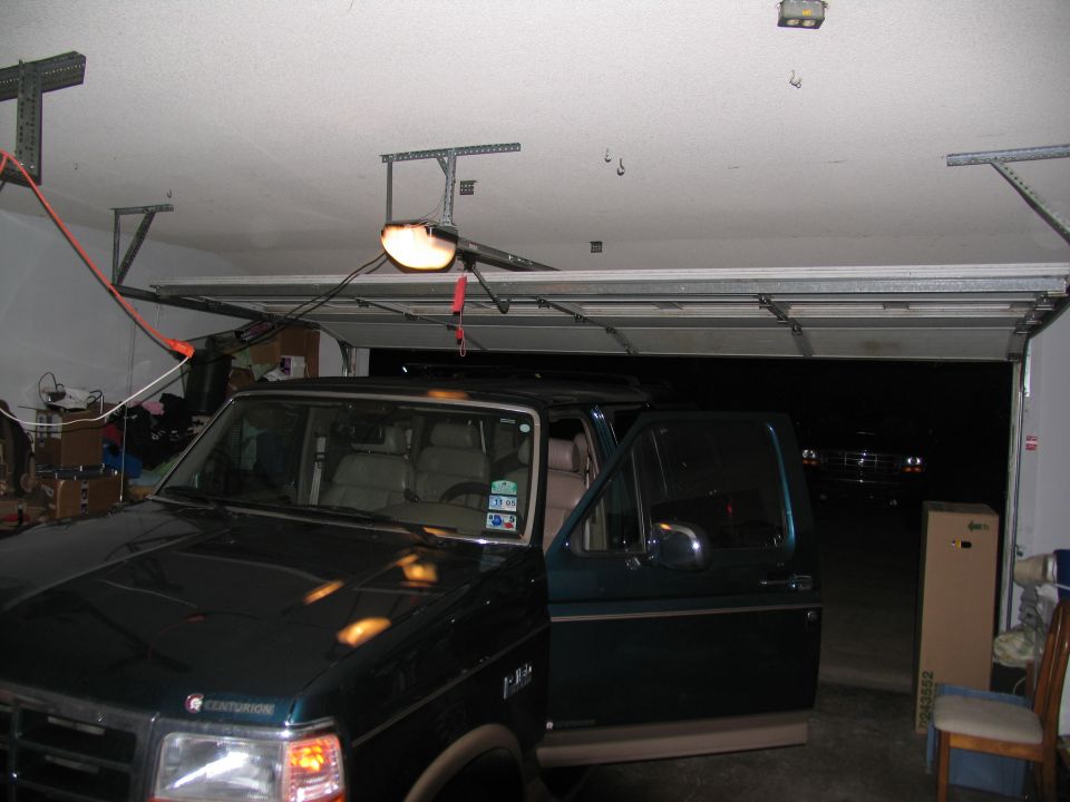 1995 Ford C-150 (Centurion Conversions) parked in a garage with the driver's door open