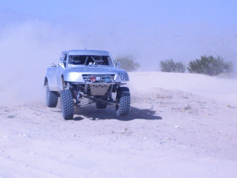 Silver number-708 off-road race truck head-on with dual lights