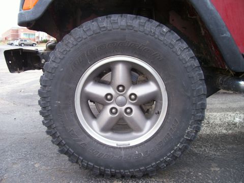 1998 Jeep TJ - Close-up of a 1998 Jeep TJ's wheel and BFGoodrich All-Terrain T/A tires, indicating a lifted suspension setup.
