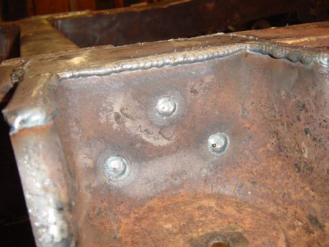 1967 Ford Bronco - Detail of a heavily rusted metal frame, showing numerous welds and bolt heads, likely during restoration.
