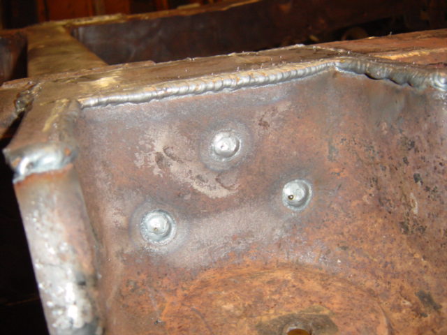 Close-up of rusted metal frame with visible welds and bolt heads