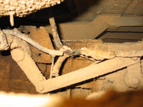 1995 Ford Bronco - Close-up of a dusty vehicle undercarriage linkage and wiring.