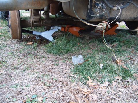 1988 Ford Bronco - Vehicle is raised on jack stands, showing the underside, fuel tank, and suspension components.