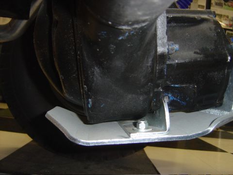 1990 Ford Bronco - Close view of a fabricated aluminum skid plate bolted beneath a black differential housing over a checkered shop floor.