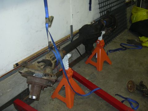 1991 Ford Bronco - Vehicle axle assembly on jack stands, likely undergoing maintenance or repair.