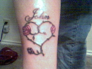 1985 Ford Bronco - A tattoo of a heart with roses and the name John is visible on a person's leg.
