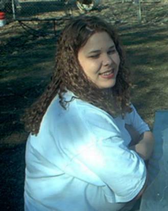 1985 Ford Bronco - A woman with curly brown hair smiles while wearing a white t-shirt outdoors. The Supermotors logo is visible in the lower right corner.