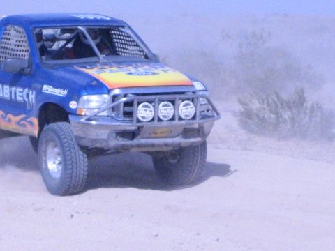 Close view of blue flamed Fabtech Ford race truck front end with light bar