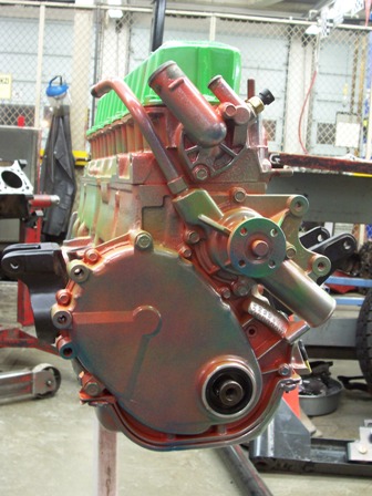 1988 Jeep Cherokee - This engine block, possibly from a Jeep Cherokee, is painted in multiple colors and sits on a stand in a garage setting.