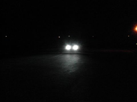2000 Dodge Durango - Headlights of a vehicle illuminate a dark road at night.