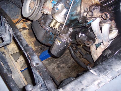 1967 Ford Mustang - Close-up of an engine bay, focusing on the oil filter and fuel pump assembly.