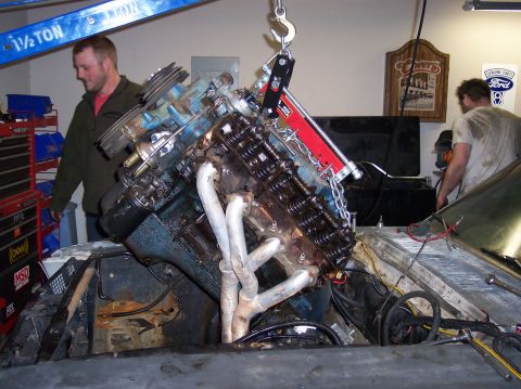 1967 Ford Mustang - Engine removal in progress, with a hoist lifting the V8 engine out of the vehicle's engine bay.