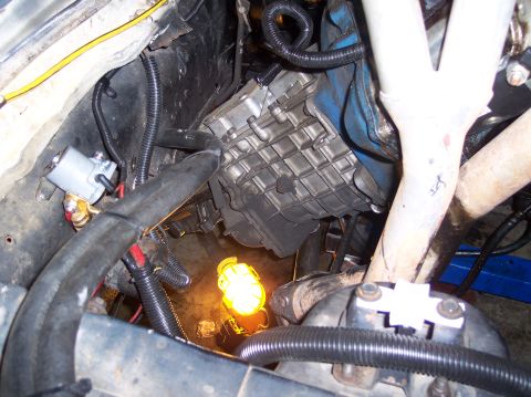 1967 Ford Mustang - The engine compartment of a vehicle, with focus on the transmission and surrounding mechanical components.