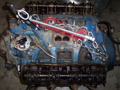 1967 Ford Mustang - A blue engine block is equipped with a red engine hoist and chains, ready for transport or installation.