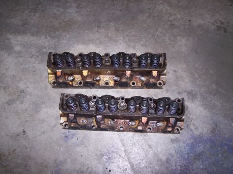 1967 Ford Mustang - Pair of engine cylinder heads shown on a concrete surface.