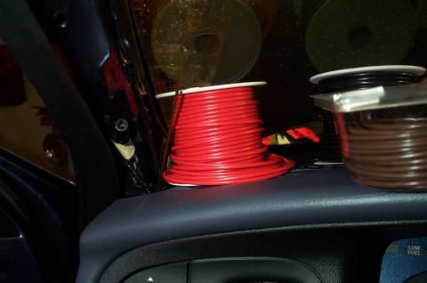 1998 Ford Crown Victoria - Wire spools and CDs are visible inside a vehicle, with a Supermotors.net logo in the corner.