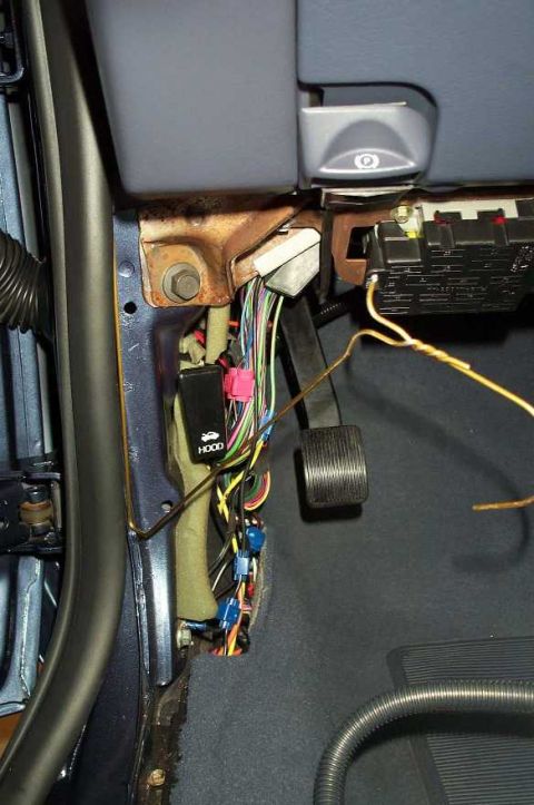 1998 Ford Crown Victoria - Close-up of vehicle interior wiring harness and components, including a fuse box and brake pedal.