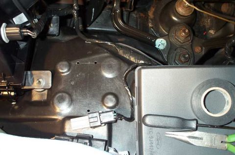 1998 Ford Crown Victoria - The holes drilled for the tach adapter. The pick used to pierce the grommet can be seen on the fusebox.