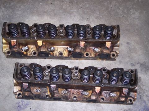 1967 Ford Mustang - A pair of engine cylinder heads are shown, each with multiple spark plugs and valve springs visible.
