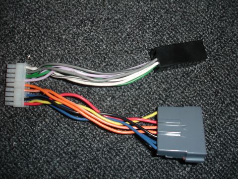1993 Ford Taurus - Two wiring harness adapters for car radios are shown, each with a different connector and array of colored wires.