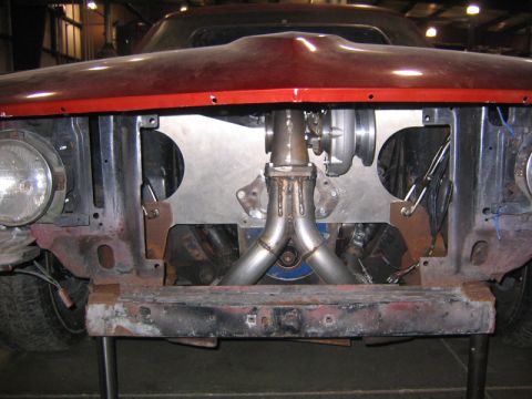 1969 Ford Mustang - The front of a 1969 Ford Mustang shows a custom turbocharger setup, with visible modifications to the engine bay.