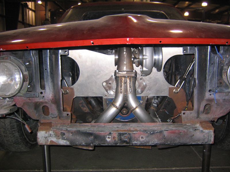 1969 Ford Mustang front end with custom turbocharger installation, red hood, rusty bumper
